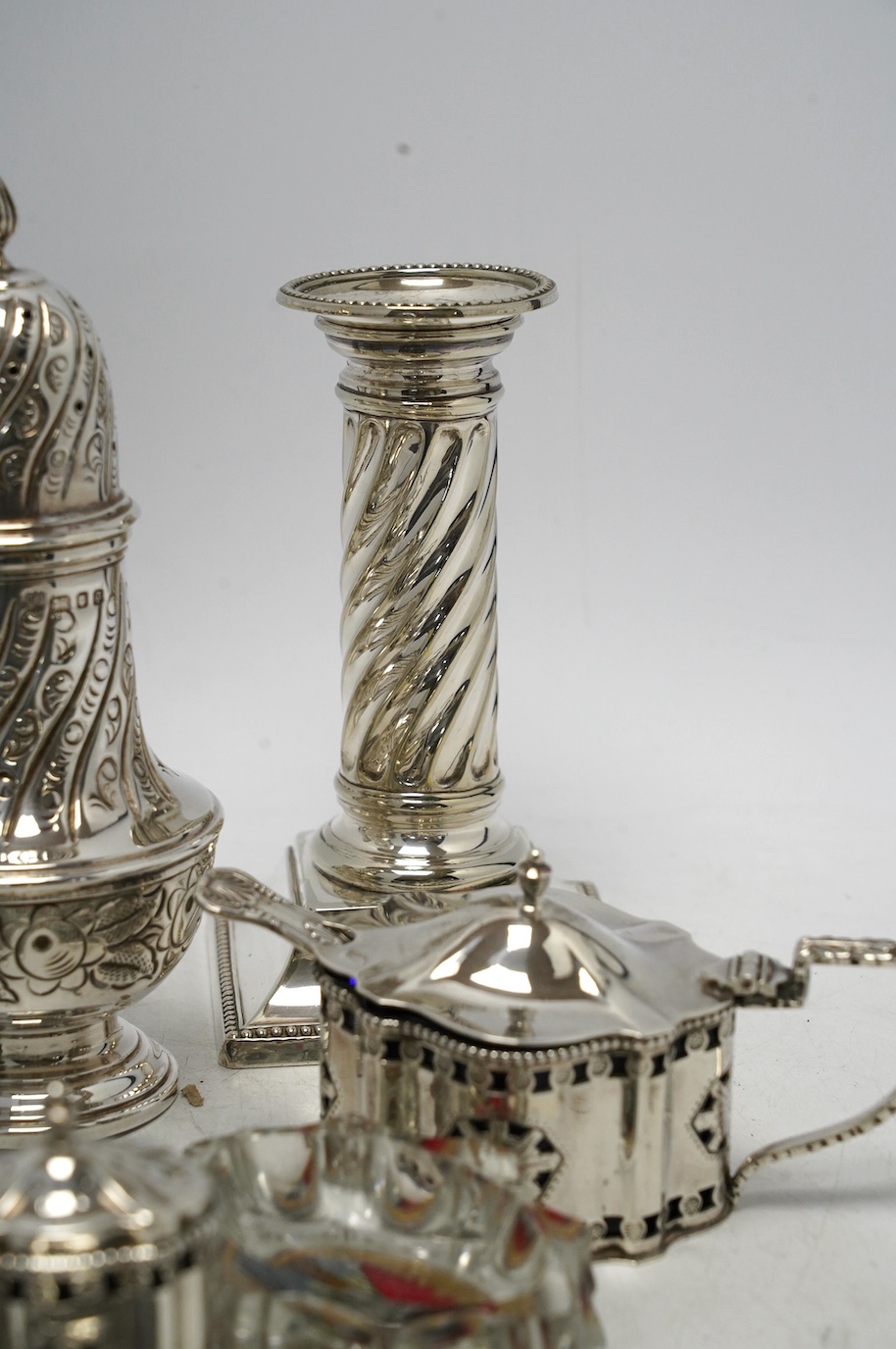 A 1970's silver sugar caster, a modern silver three piece condiment set, a silver oval dish and four other items including a pair of silver plated dwarf candlesticks. Condition - poor to fair
